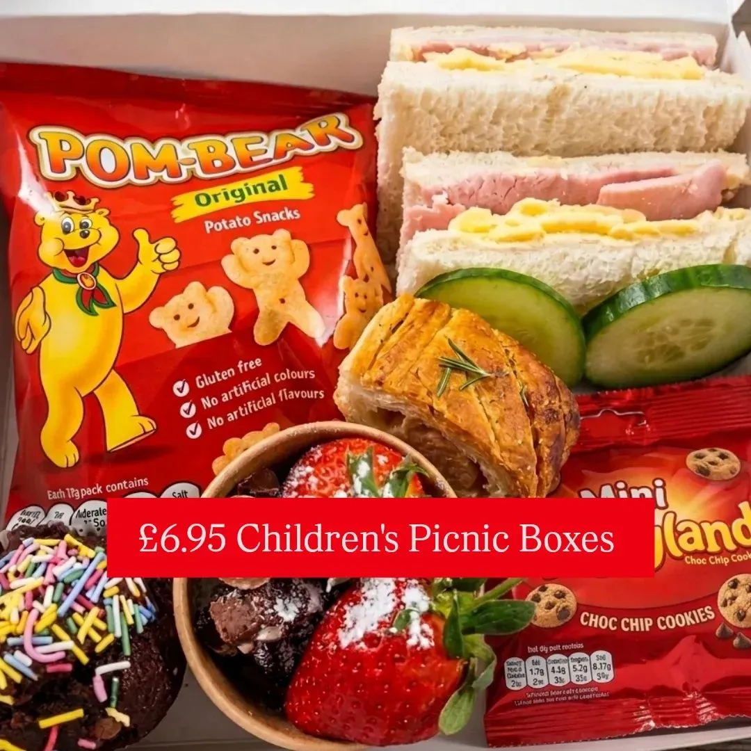 A children's hamper box with sandwiches, sausage roll and cookies