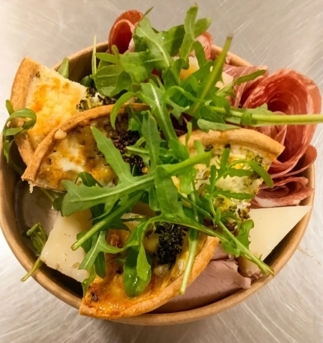 A graze bowl of cheese, charcuterie, hummus and salad
