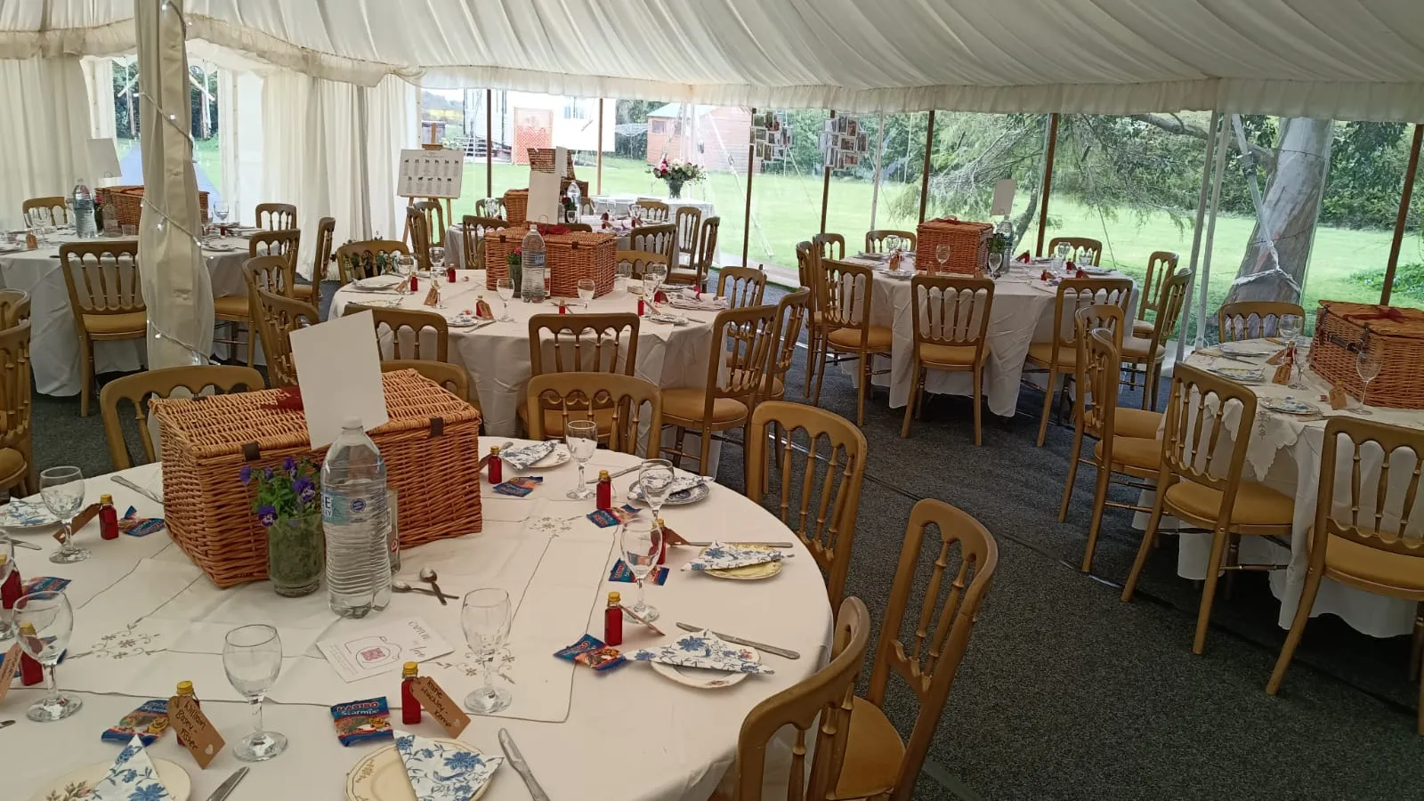A picnic blanket laid with food boxes, scones and a wicker hamper