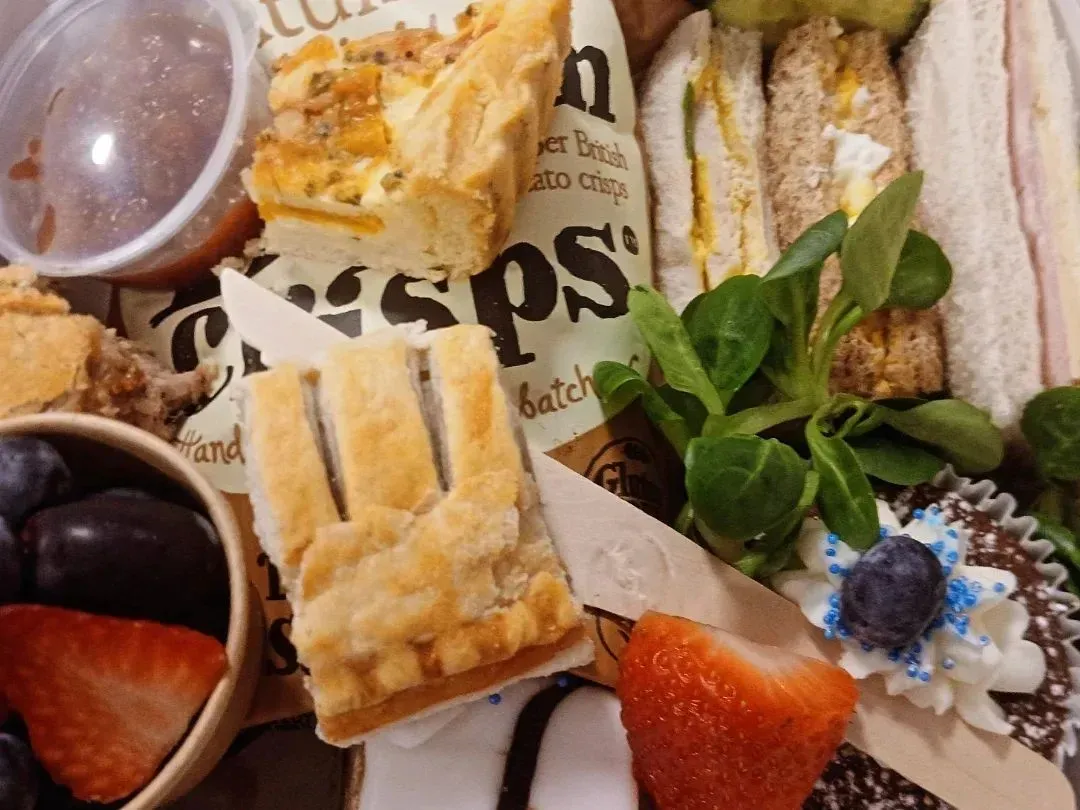 A posh picnic box with sandwiches, pork pie, chutney and Bakewell slice