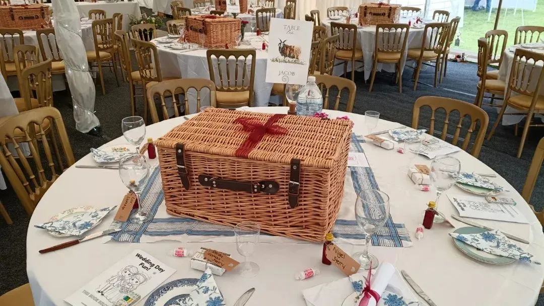 A wicker hamper centrepiece on a dressed wedding table