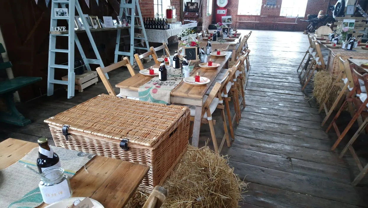 Wicker hampers laid as wedding centrepieces in a marquee